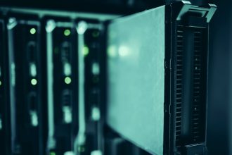 Racks de servidores em um data center moderno, iluminados em tons de azul.